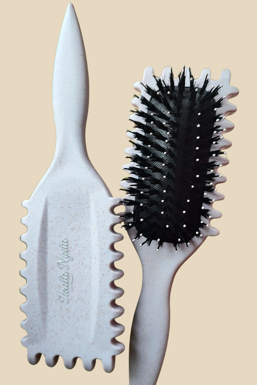 Vue avant et arrière de la brosse définissante Ikala Ngita, avec ses dents ondulées et ses picots souples.