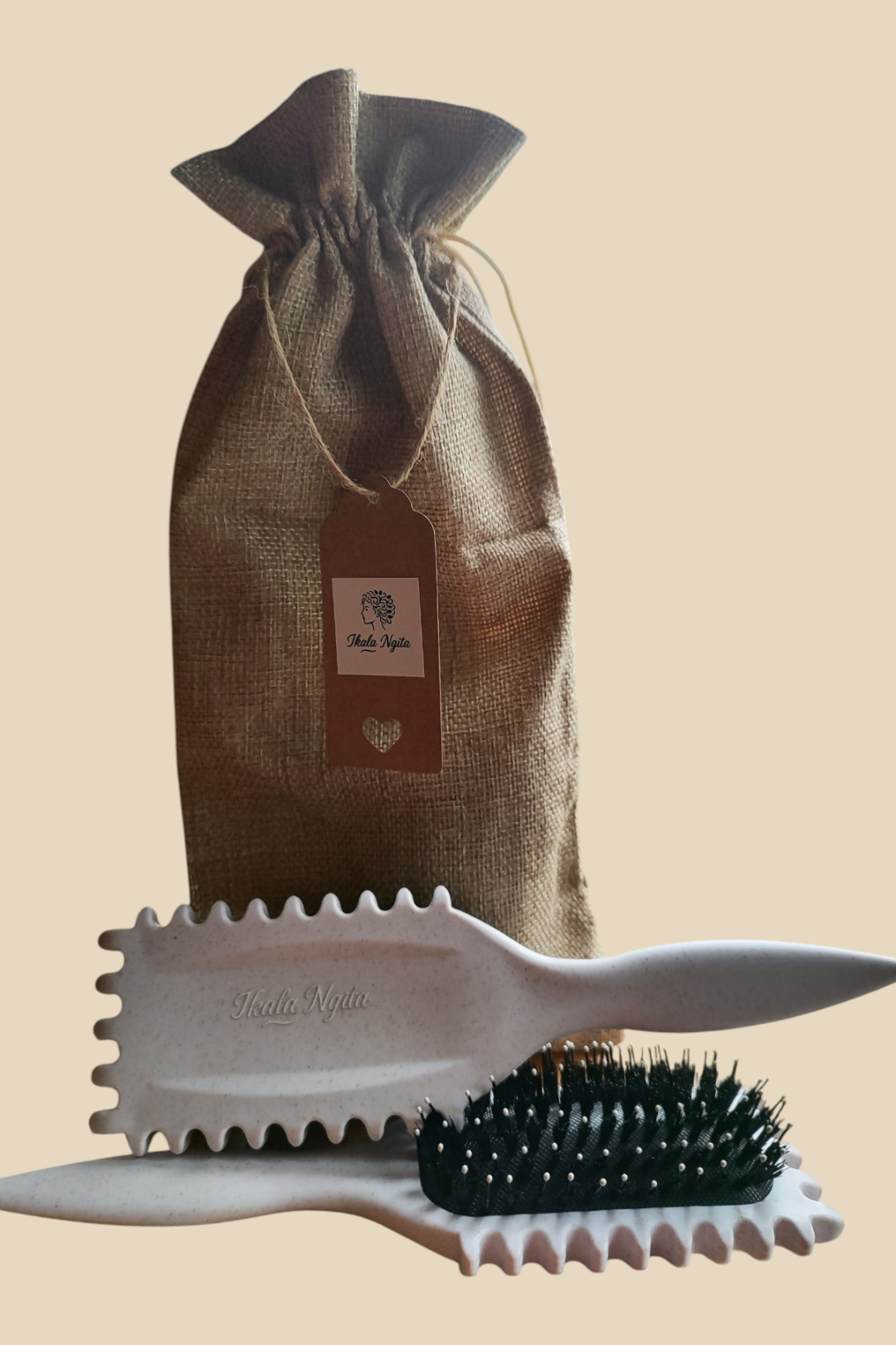 Brosse à cheveux texturée Ikala Ngita accompagnée de son sac en toile de jute , posée verticalement