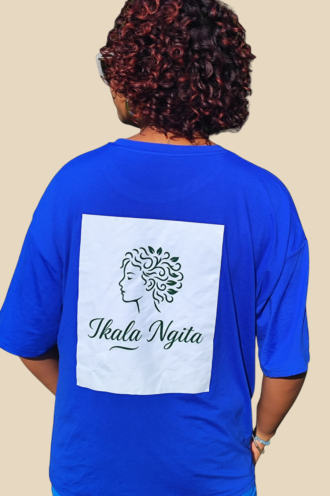 T-shirt orange Ikala Ngita – Vue de dos, logo sérigraphié  vert sapin sur fond blanc, vêtement casual mode afro