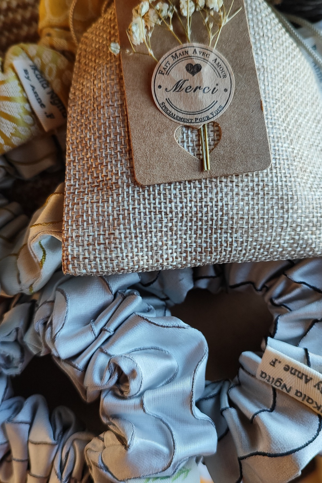 Ensemble de chouchous Ikala Ngita dans un sac en jute réutilisable, packaging écoresponsable et artisanal.